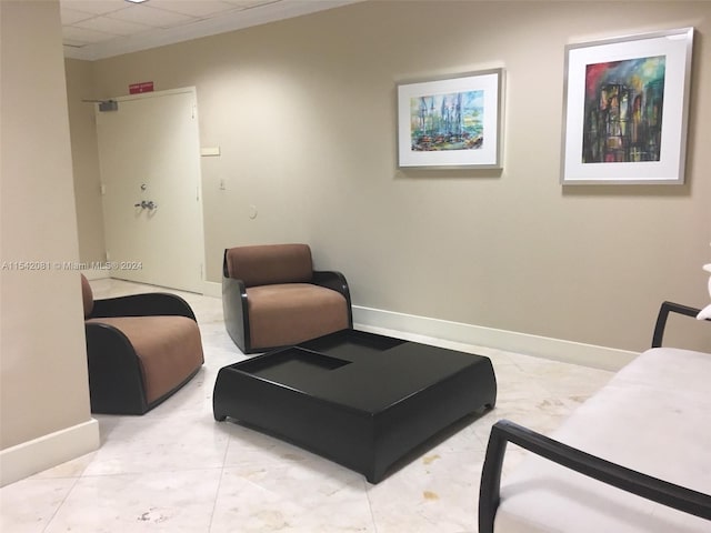 sitting room with light tile floors and a drop ceiling