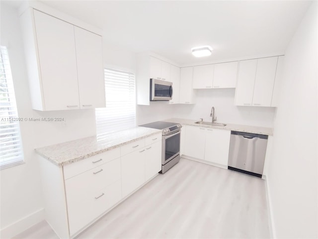 kitchen with white cabinets, appliances with stainless steel finishes, and sink