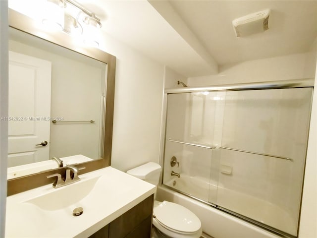 full bathroom featuring shower / bath combination with glass door, vanity, and toilet