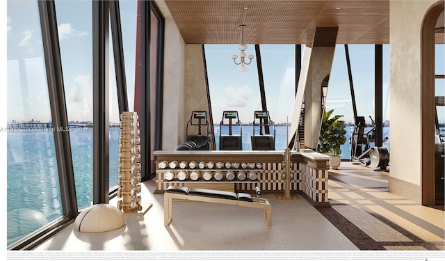 sunroom / solarium featuring a water view, a notable chandelier, and plenty of natural light