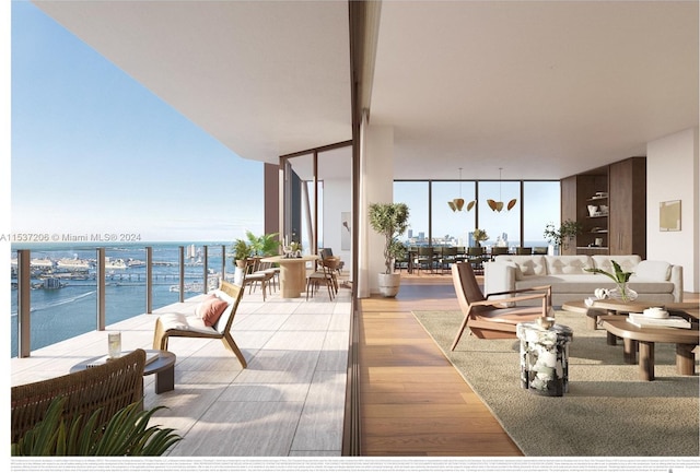 living room with a water view, expansive windows, a wealth of natural light, and light wood-type flooring