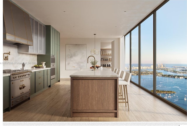 kitchen with hardwood / wood-style flooring, expansive windows, a center island with sink, a water view, and backsplash