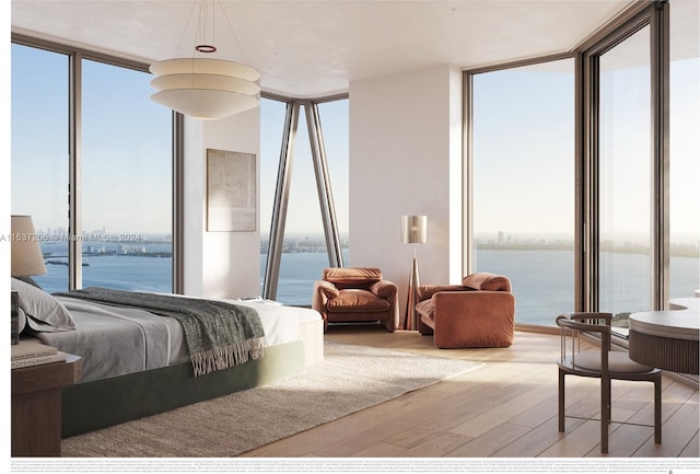 bedroom with a water view, light hardwood / wood-style flooring, and a wall of windows