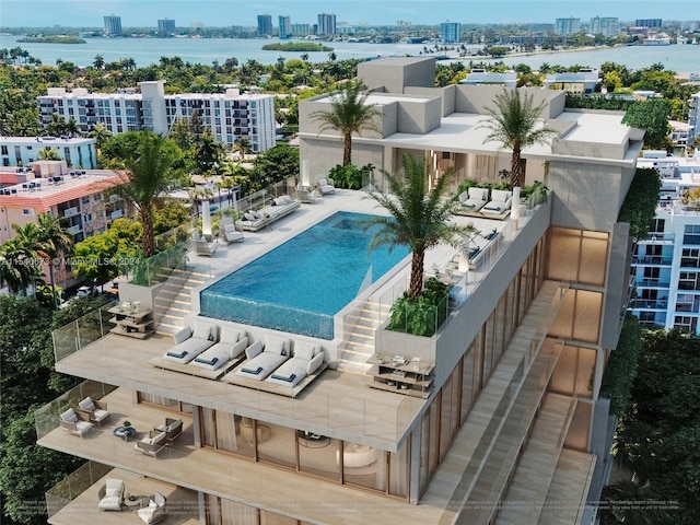 view of swimming pool with a water view and a patio area