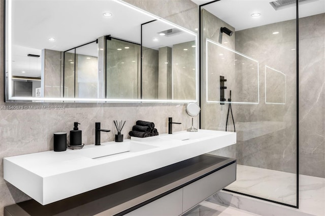 bathroom featuring tile walls, dual bowl vanity, and walk in shower