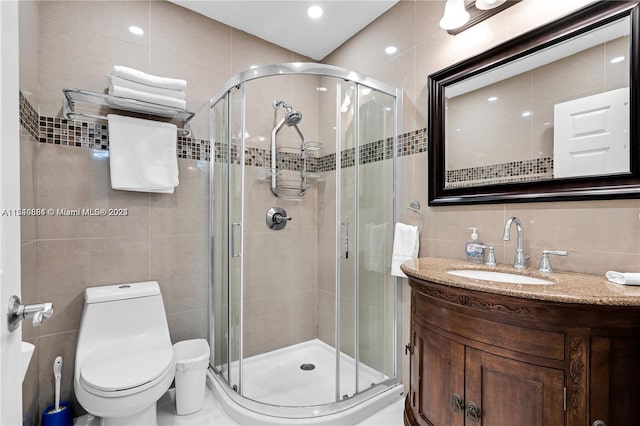 bathroom with tile walls, toilet, a shower with shower door, tasteful backsplash, and vanity