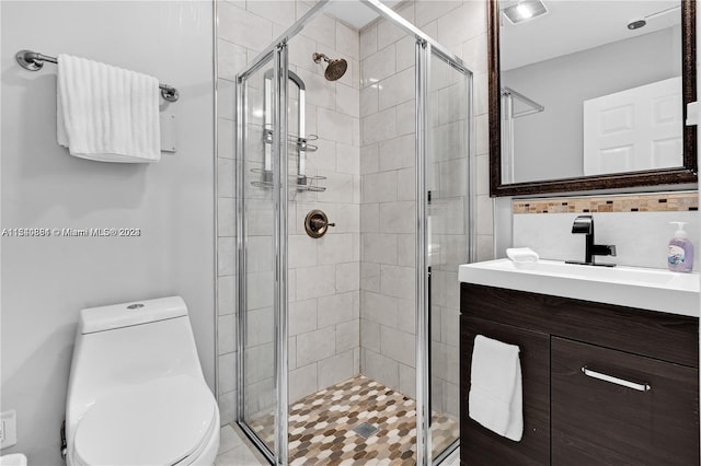 bathroom with a shower with door, vanity with extensive cabinet space, and toilet