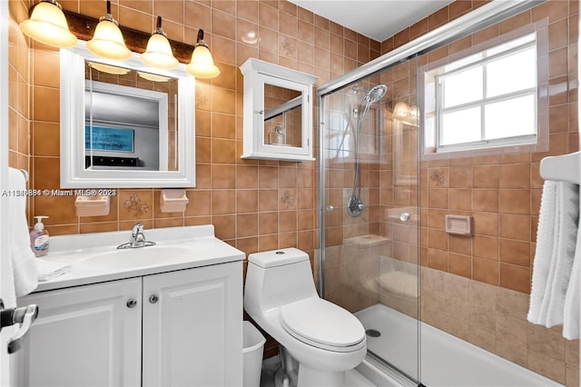 bathroom with tile walls, toilet, vanity, and tasteful backsplash