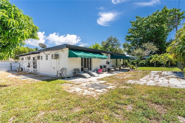 rear view of house featuring a lawn and a patio area