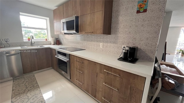 kitchen featuring tasteful backsplash, sink, light tile patterned floors, and stainless steel appliances