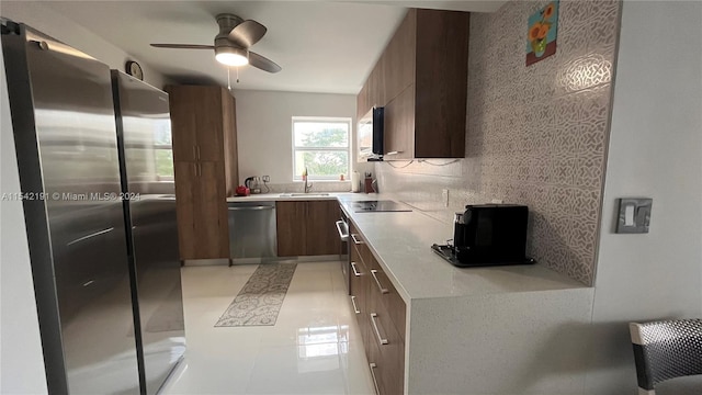 kitchen with ceiling fan, sink, stainless steel appliances, tasteful backsplash, and light tile patterned floors