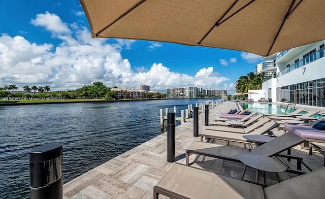 dock area with a water view and a community pool