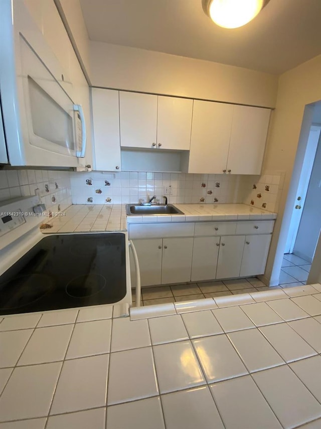 kitchen with white cabinets, tasteful backsplash, and sink