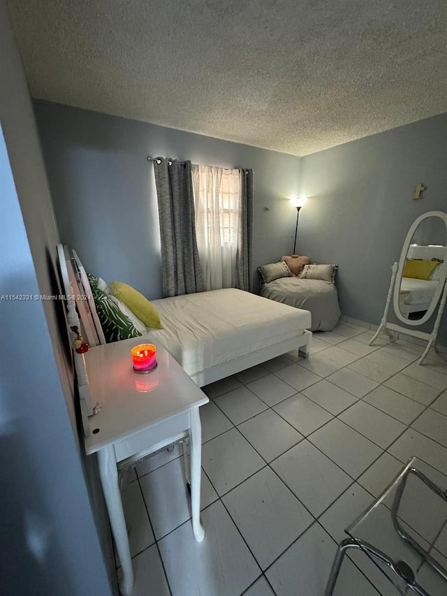 bedroom with a textured ceiling and light tile flooring