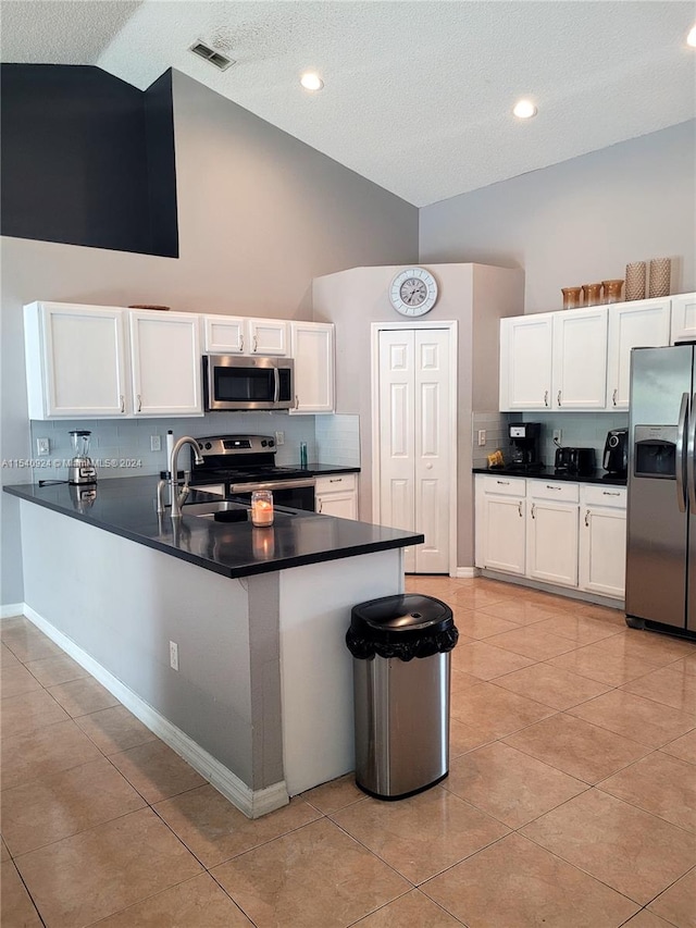 kitchen featuring appliances with stainless steel finishes, kitchen peninsula, and white cabinets