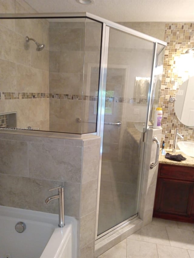 bathroom with tile patterned floors, decorative backsplash, vanity, tile walls, and shower with separate bathtub