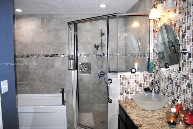 bathroom with vanity, backsplash, independent shower and bath, and a textured ceiling