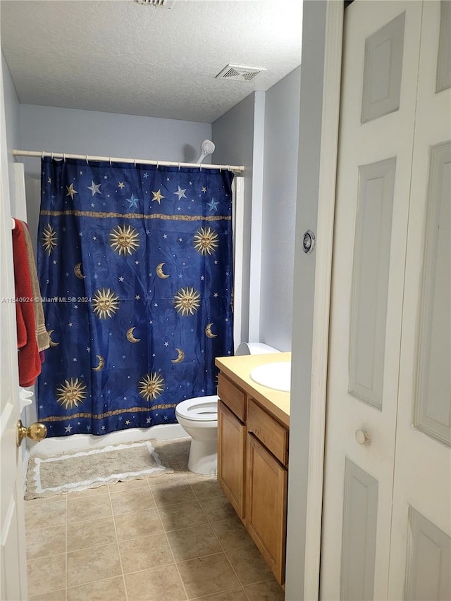 full bathroom with tile patterned floors, shower / bath combo, toilet, vanity, and a textured ceiling