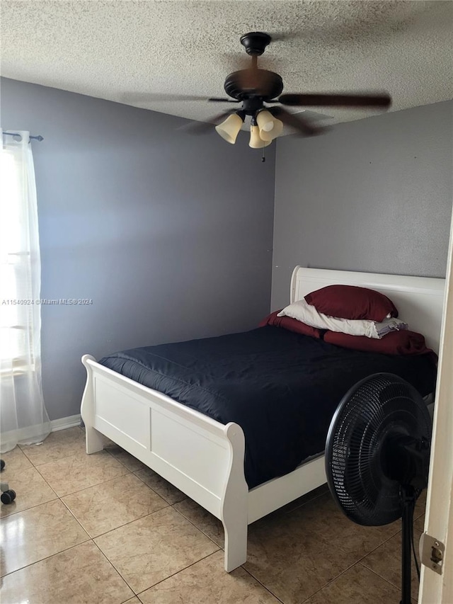 tiled bedroom with a textured ceiling and ceiling fan