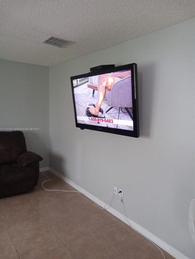 sitting room with a textured ceiling and tile patterned flooring