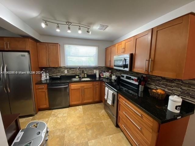 kitchen with tasteful backsplash, appliances with stainless steel finishes, light tile floors, and sink