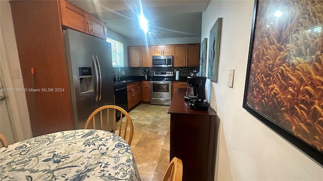 kitchen with light tile floors, appliances with stainless steel finishes, tasteful backsplash, and sink