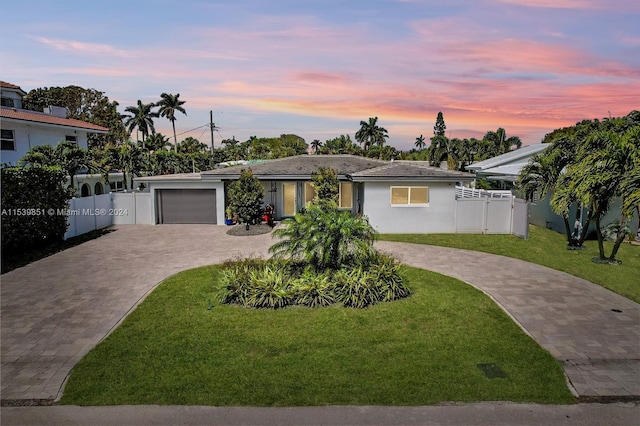 view of front of property with a garage and a yard