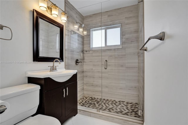 bathroom featuring tile patterned flooring, toilet, vanity, and walk in shower