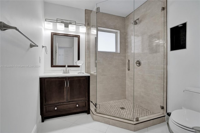 bathroom featuring tile patterned flooring, vanity, toilet, and a shower with shower door