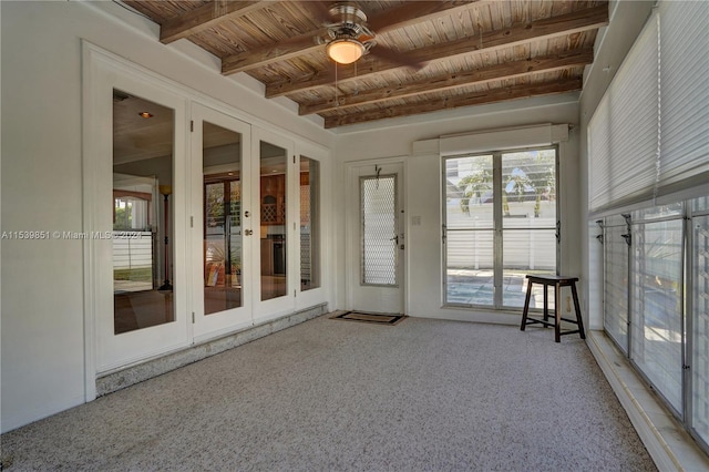 unfurnished sunroom featuring beamed ceiling, ceiling fan, wood ceiling, and french doors