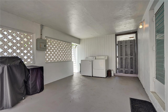 basement featuring washing machine and dryer, electric panel, and plenty of natural light