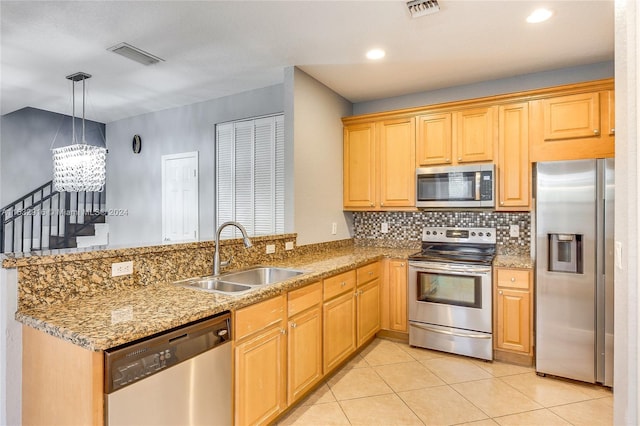 kitchen with kitchen peninsula, sink, light tile floors, appliances with stainless steel finishes, and an inviting chandelier