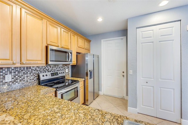 kitchen with backsplash, stainless steel appliances, light tile floors, and light stone counters