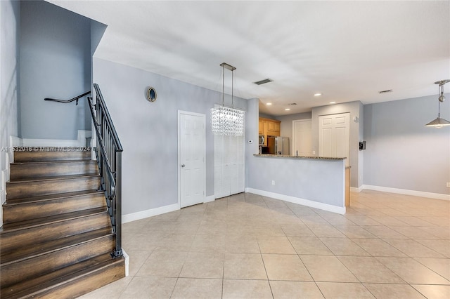 tiled foyer entrance with a chandelier