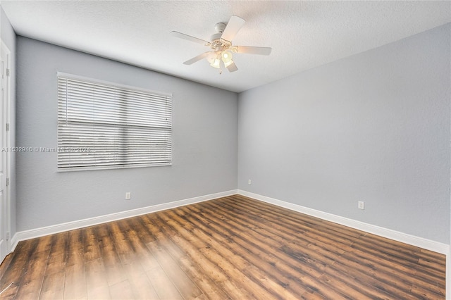 empty room featuring ceiling fan, a textured ceiling, and dark wood-type flooring