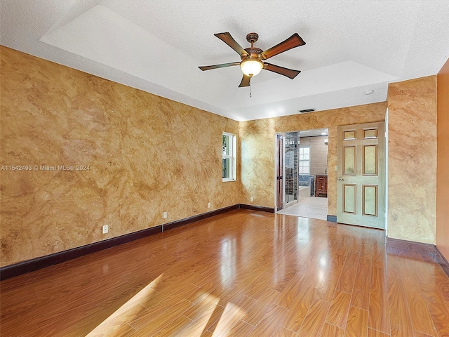 spare room with ceiling fan, a textured ceiling, and light wood-type flooring