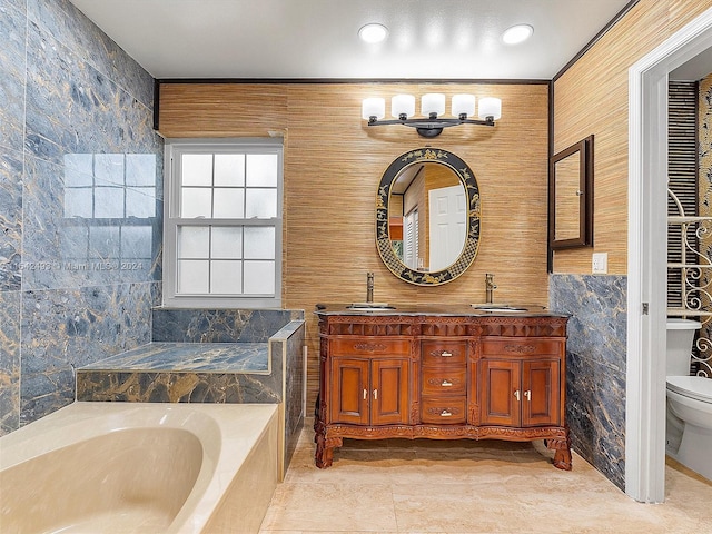 bathroom featuring vanity with extensive cabinet space, tile floors, tile walls, a washtub, and double sink