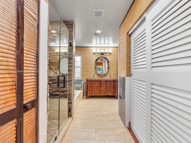 hall featuring wooden walls, sink, and light tile flooring