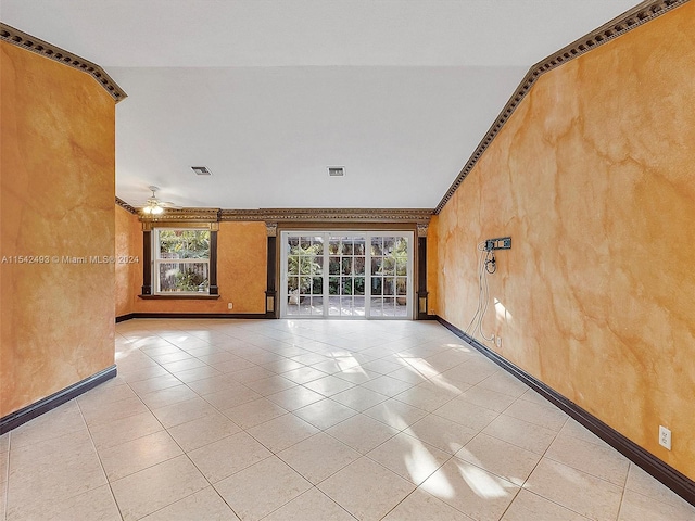 tiled empty room featuring ornamental molding and ceiling fan