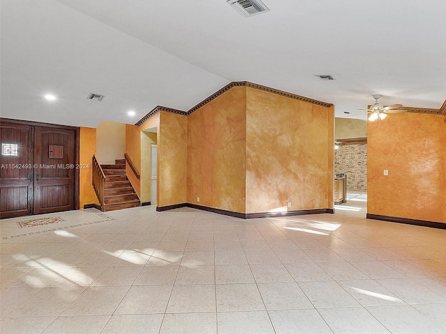 spare room with ceiling fan and light tile flooring