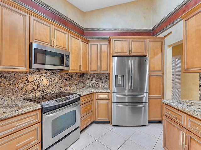 kitchen featuring backsplash, appliances with stainless steel finishes, light tile floors, and light stone counters