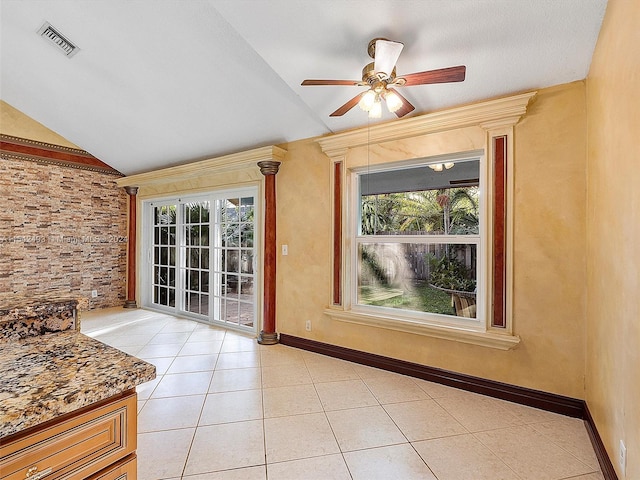 empty room with lofted ceiling, plenty of natural light, ceiling fan, and light tile flooring