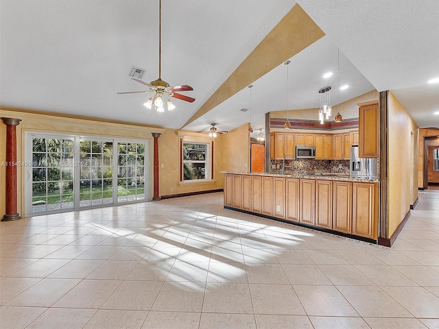 kitchen featuring decorative light fixtures, ceiling fan, stainless steel appliances, light tile flooring, and dark stone countertops