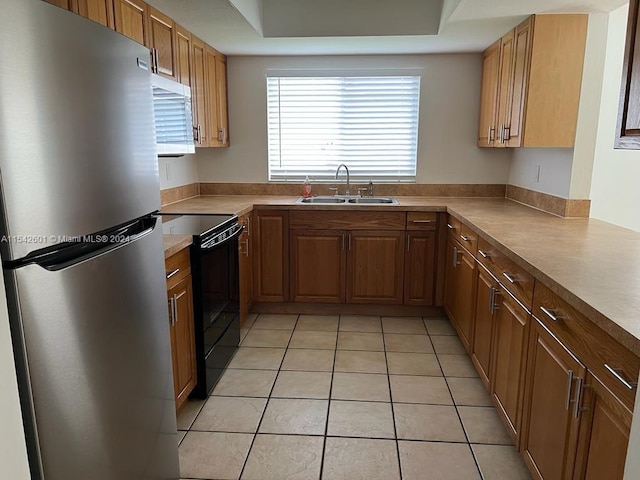 kitchen featuring light tile floors, sink, stainless steel fridge, and black range with electric cooktop