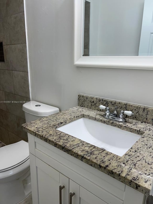 bathroom featuring oversized vanity and toilet