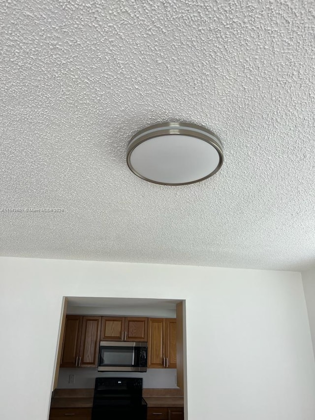 interior details featuring stove and a textured ceiling