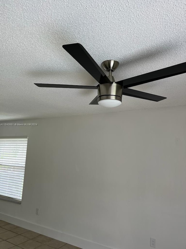 room details with tile flooring, ceiling fan, and a textured ceiling