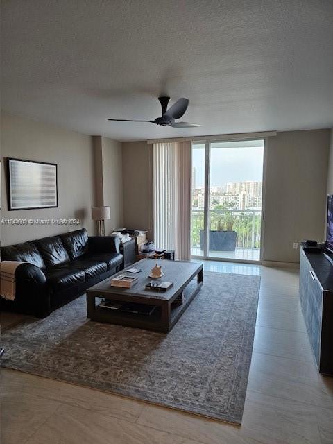 living room featuring a textured ceiling and ceiling fan