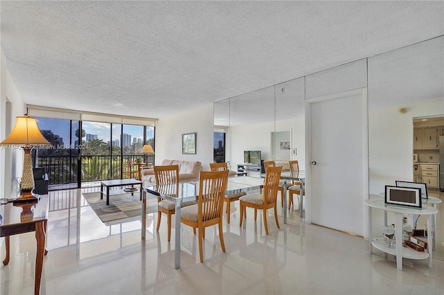 dining room with floor to ceiling windows, a textured ceiling, and light tile floors