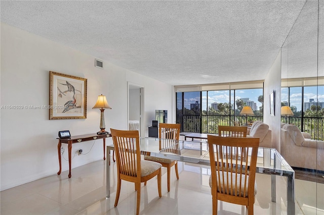 dining space featuring floor to ceiling windows, a textured ceiling, and light tile flooring